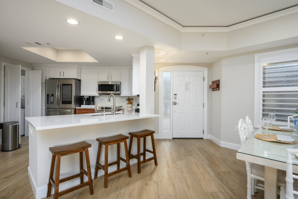 Spacious open-concept design with kitchen island seating and a light-filled living area.