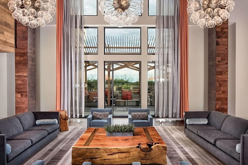 Gather in a soaring, light-filled lounge with designer comfort.