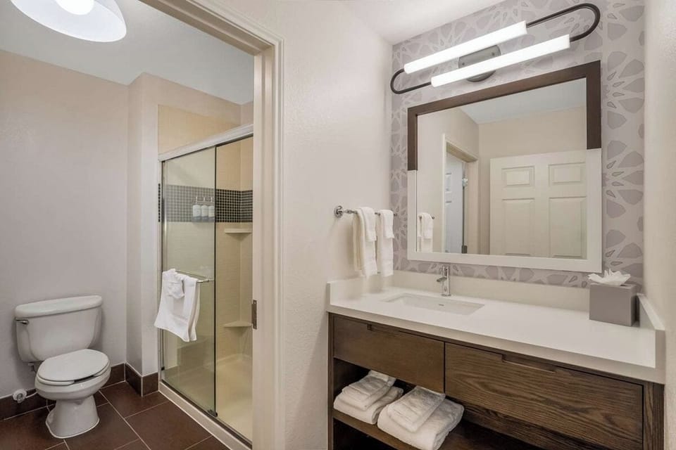 Refresh easily in a spotless bath with bright vanity lighting.