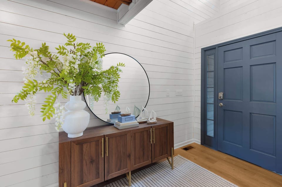 A welcoming entryway with a stunning large round mirror, setting the tone for a stylish and inviting home.