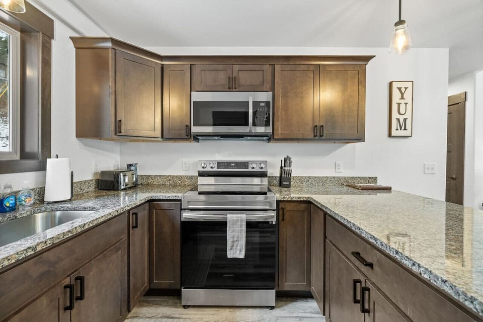 The kitchen is equipped with sleek modern amenities, including a built-in oven with a stovetop, providing a perfect space for cooking and entertaining.