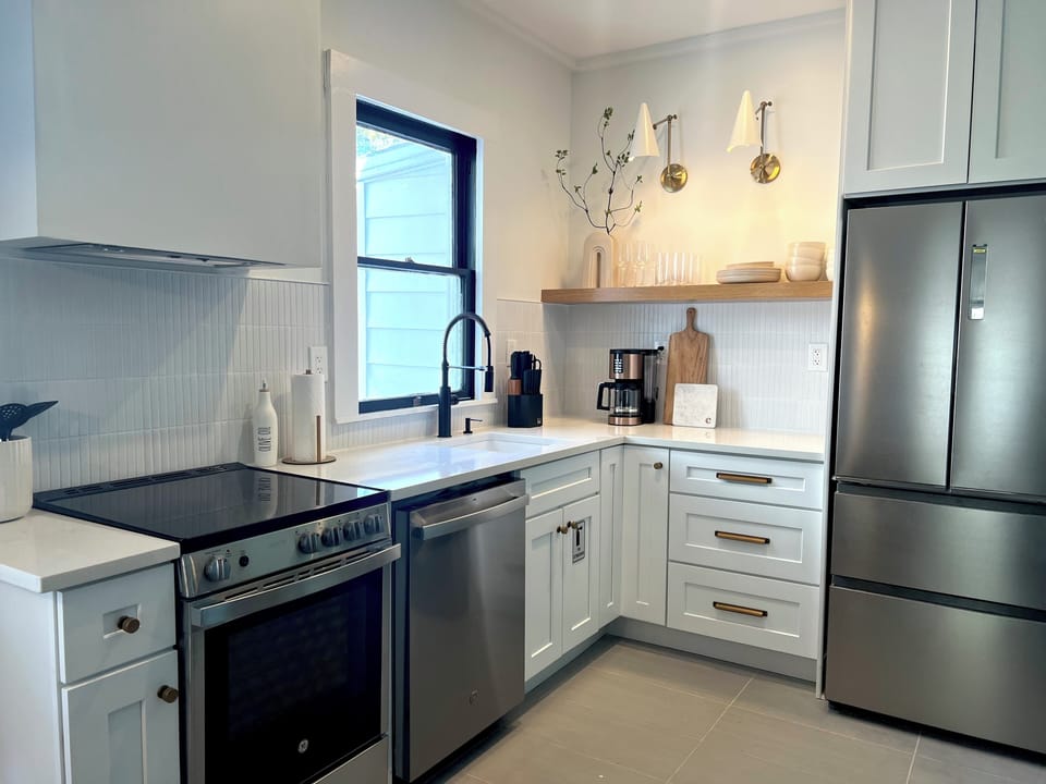 Full kitchen with microwave, oven, coffee maker and cooking utensils 