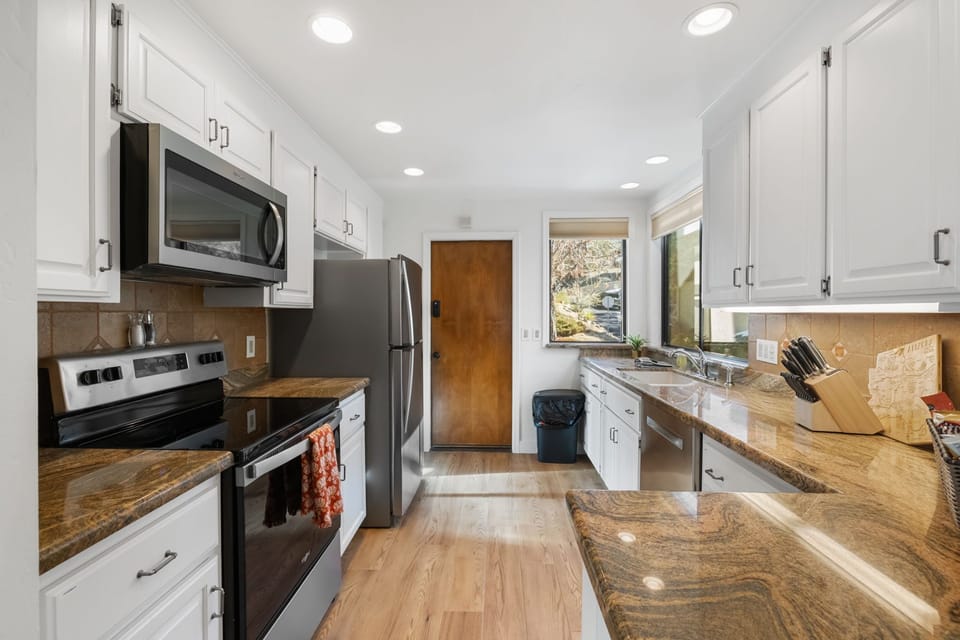 A modern, fully equipped kitchen with all the amenities seamlessly opens to the inviting living room.