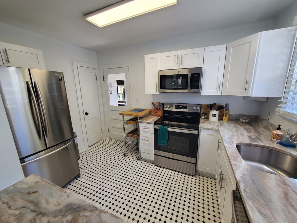 Fully-equipped kitchen with modern appliances and a classic checkered floor.