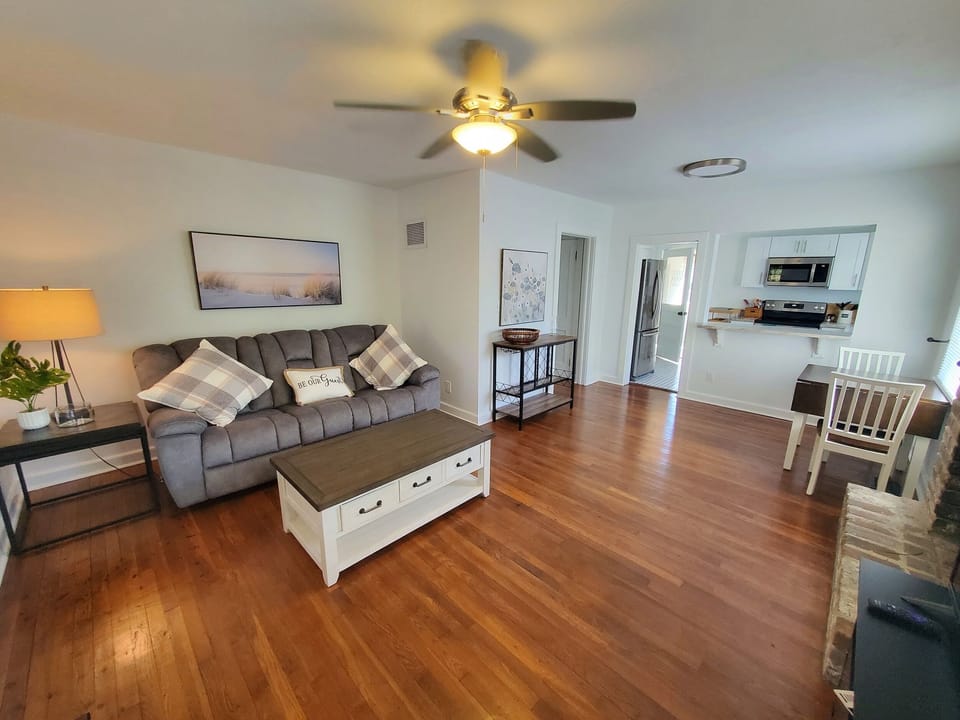 Inviting open-plan living room with hardwood floors and comfy seating.