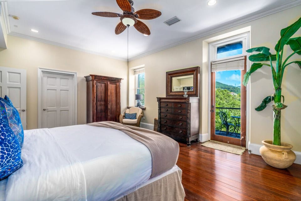 The primary bedroom (middle level) with en-suite bath and private balcony.