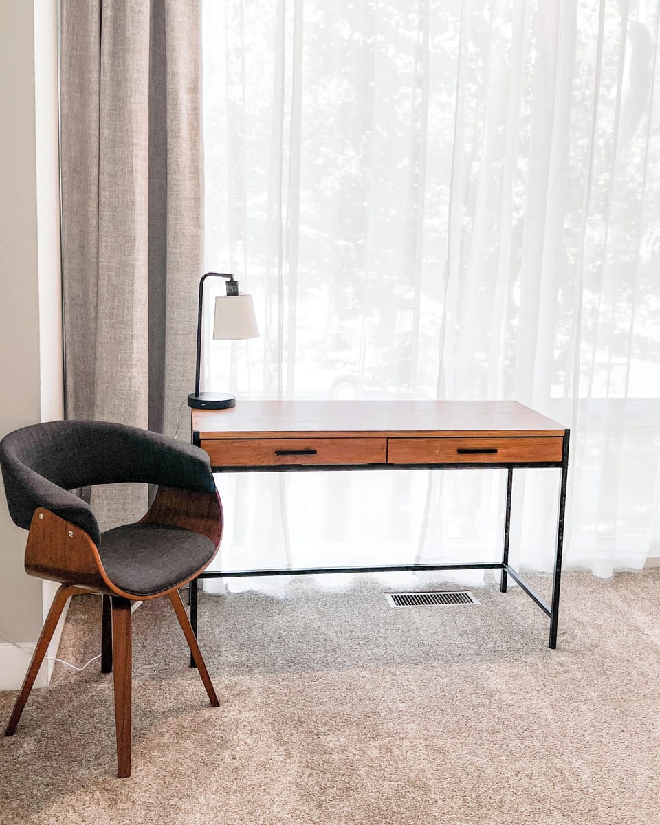 A chic work corner with a sleek desk, cozy chair, and plenty of natural light. The perfect space to work, unwind, or enjoy the view. Style and comfort meet productivity in this bright, inviting nook.