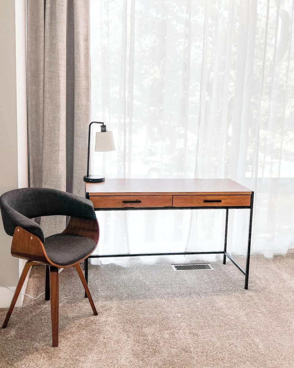 A chic work corner with a sleek desk, cozy chair, and plenty of natural light. The perfect space to work, unwind, or enjoy the view. Style and comfort meet productivity in this bright, inviting nook.