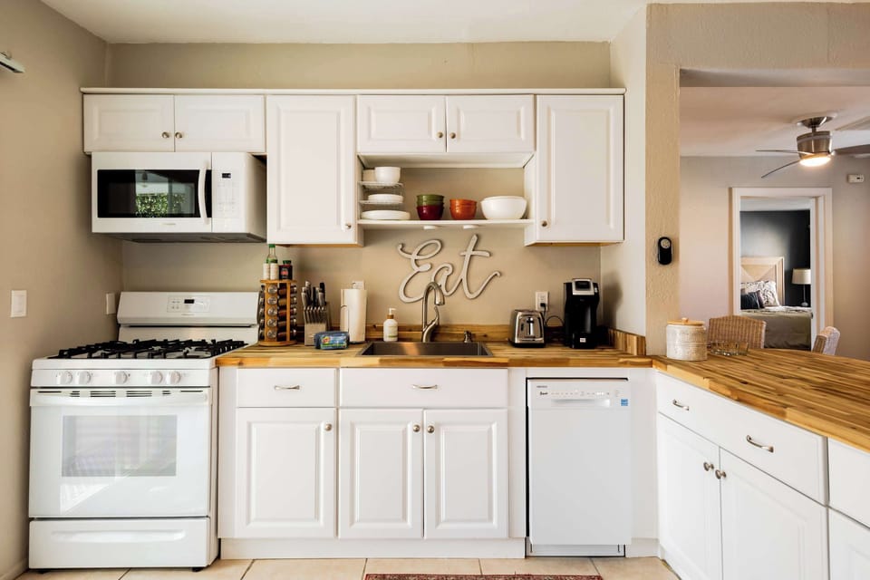 Casita kitchen with gas range, white shaker cabinets, butcher-block counters, and dishwasher — everything you need for a full cook-in