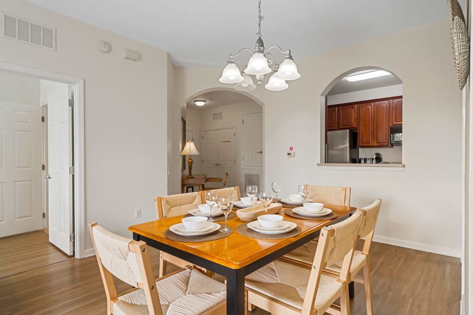 Charming dining area featuring an inviting table setup for shared moments - Arched doorways and warm lighting add character to the modern design - Perfect for enjoying delicious meals and quality time with loved ones