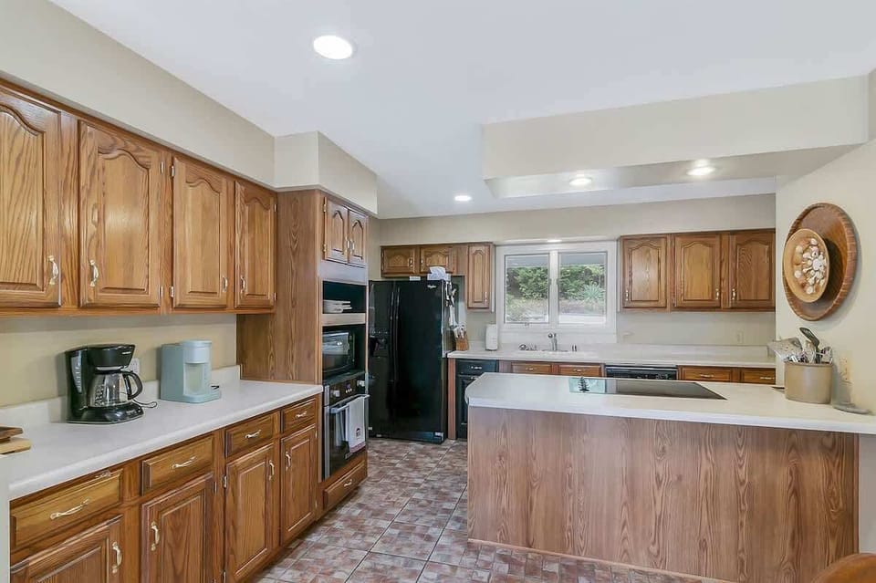 Fully equipped kitchen featuring warm wood cabinetry, generous workspace, and plenty of room to cook for a crowd.