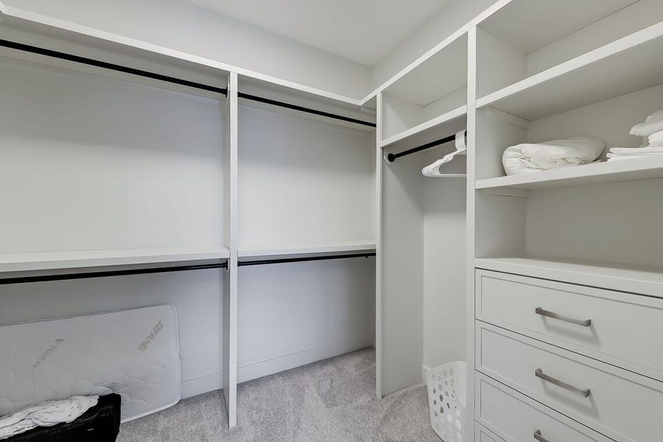 Large walk-in closet with modern built-ins + pack-and-play crib for families.