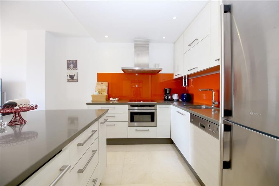 Modern open kitchen in this apartment is fully equipped with all the appliances