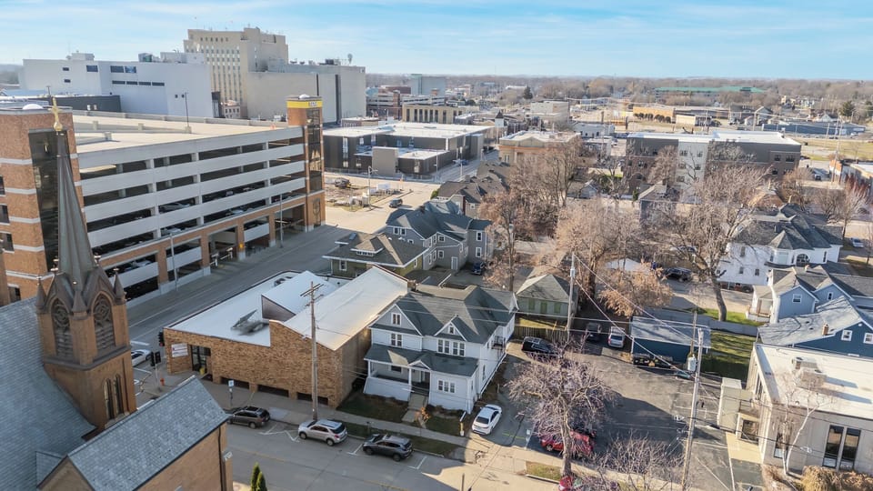 - Aerial perspective showing city connection and nearby historic architecture   - Ideal central location offering easy access to restaurants and events   - Blends modern comfort with the charm of a walkable, vibrant neighborhood