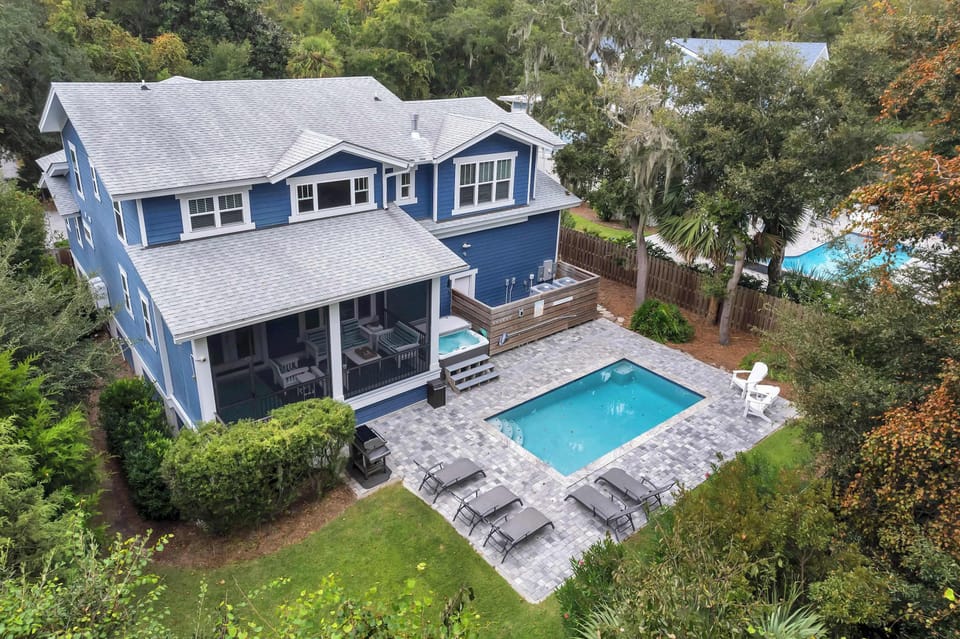Discover your secluded backyard paradise, featuring a stunning heated pool and a calming hot tub nestled amid vibrant greenery. This expansive space is designed for relaxation, providing the perfect backdrop for soaking up the sun