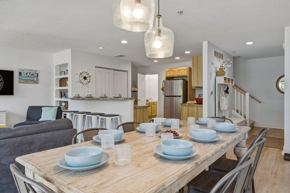 Open dining and kitchen space with coastal decor, breakfast bar seating, and a table for shared meals.