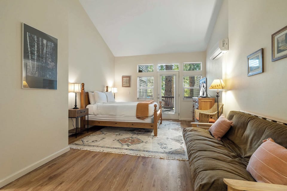 Sleeping Area with TV, direct patio access, queen bed, and sofa