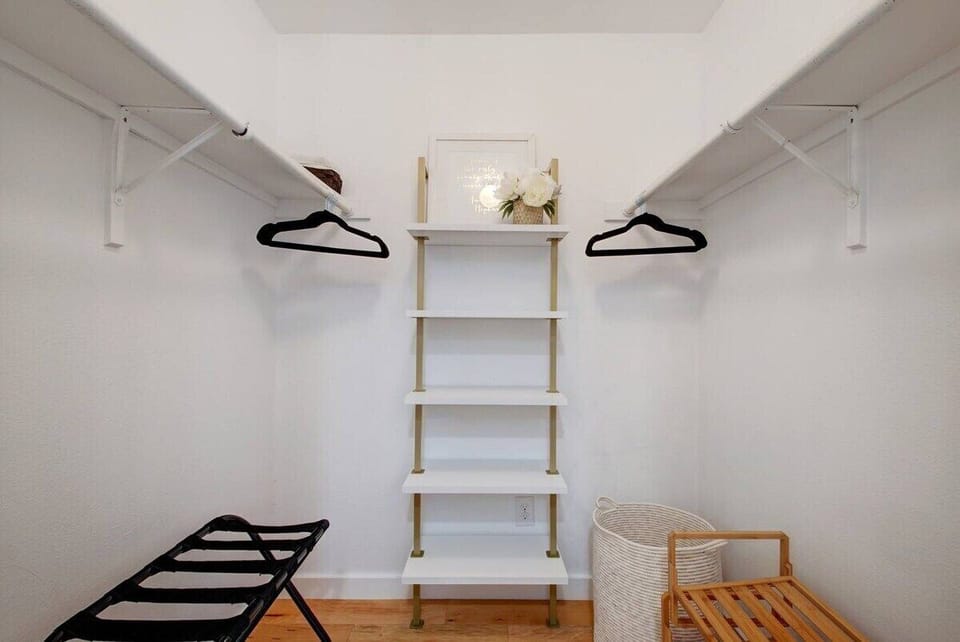The large primary closet includes a shoe rack, luggage rack, shelving, hamper, and hangers.