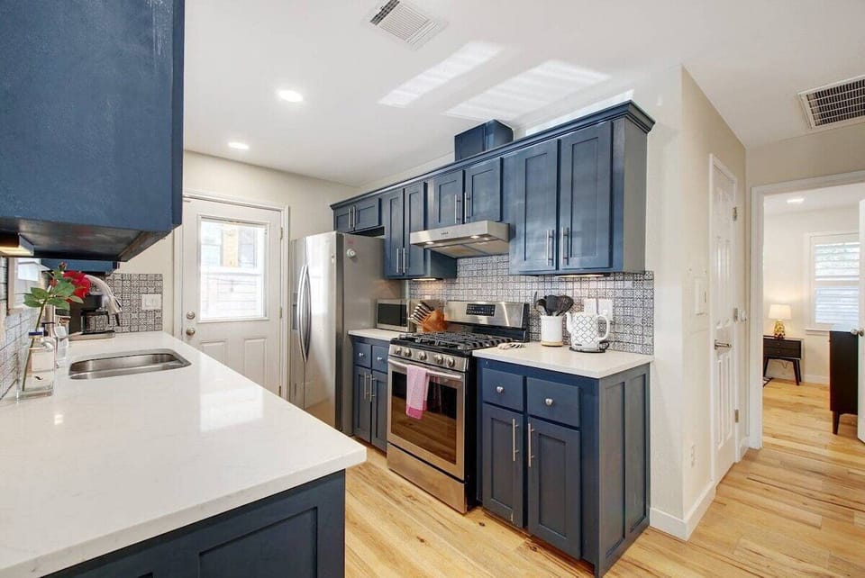 The kitchen includes Samsung and Whirlpool stainless steel appliances and other additional small appliances such as a toaster, blender, microwave, coffee maker, and more. 