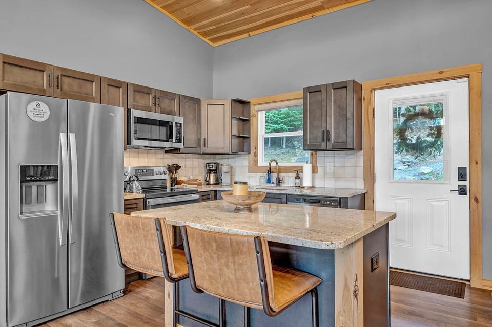 Fully stocked modern rustic kitchen with stainless steel appliances, a spacious island, and everything you need to cook and entertain during your stay