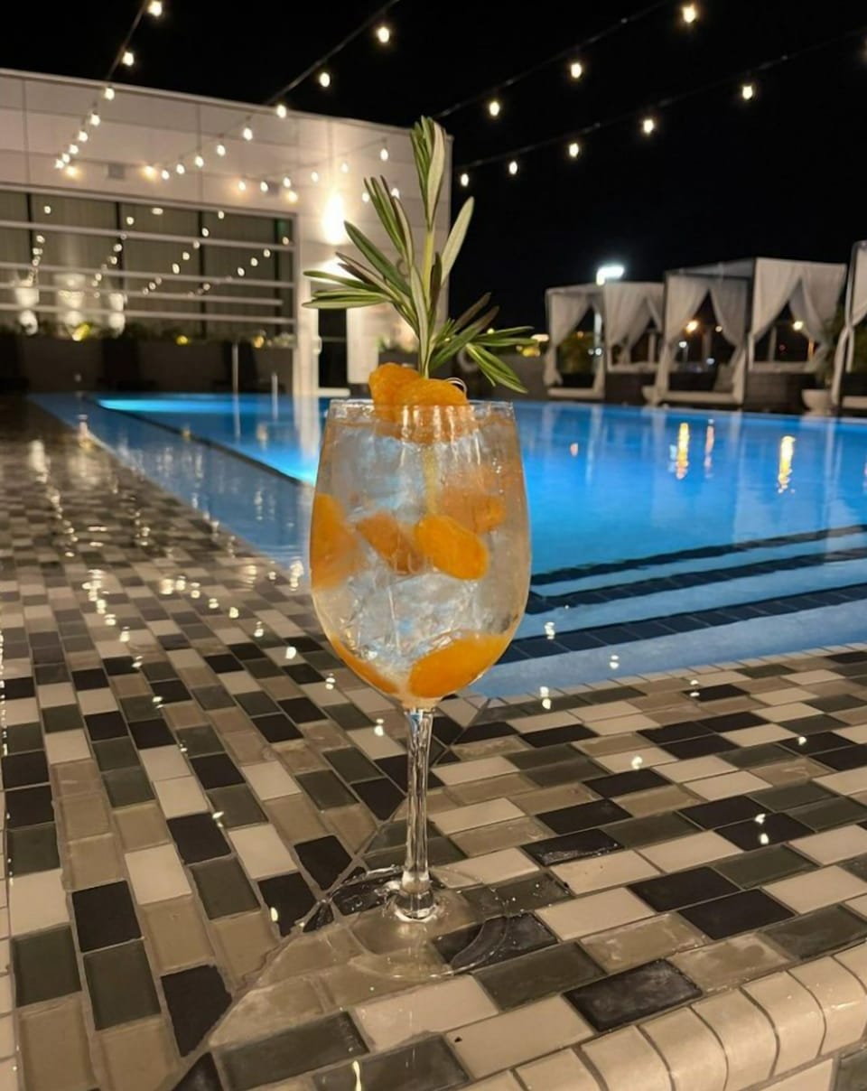Unwind poolside at night under twinkling string lights.