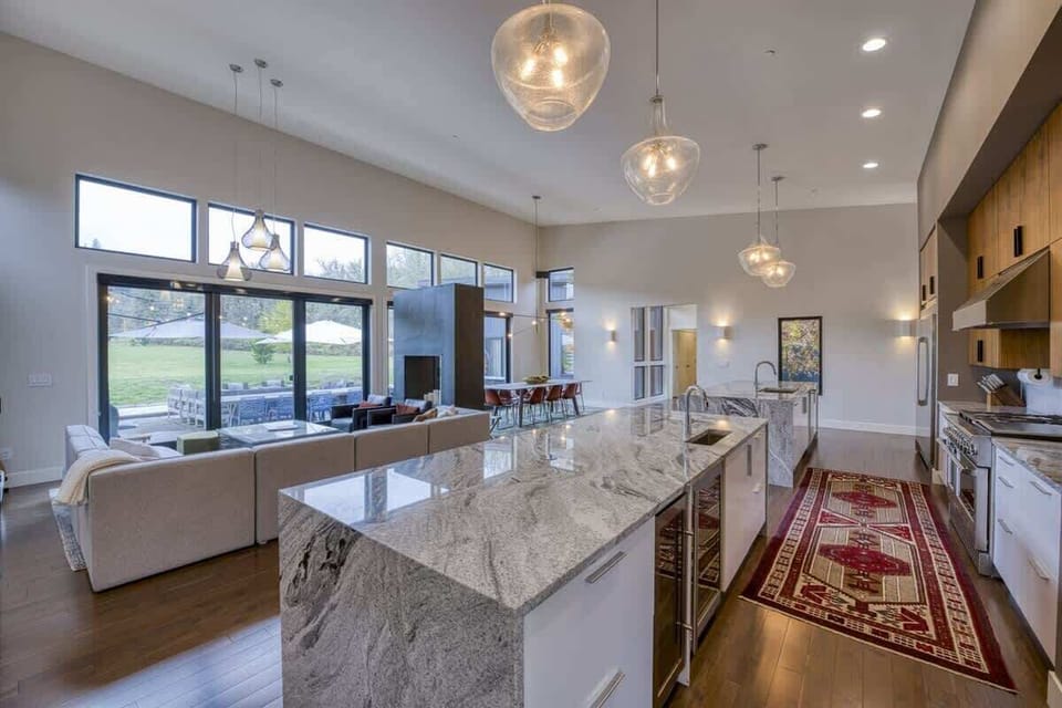 Luxury open-concept kitchen and living area with oversized island, high ceilings, and indoor-outdoor living.