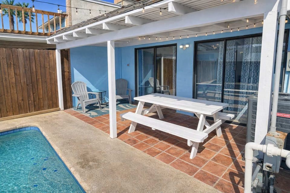 Relax by the Poolside Patio – Covered Pergola, Outdoor Dining, and Adirondack Loungers in a Sunlit Backyard Oasis
