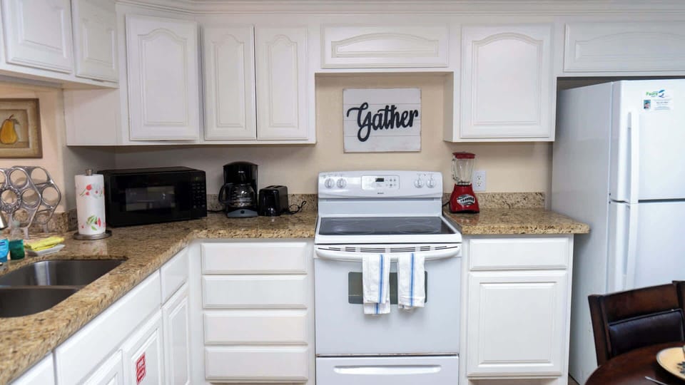 Fully equipped kitchen with modern appliances, including stove, microwave, coffee maker, toaster, and blender. Ample counter space and cabinetry make it perfect for preparing meals and enjoying family gatherings.