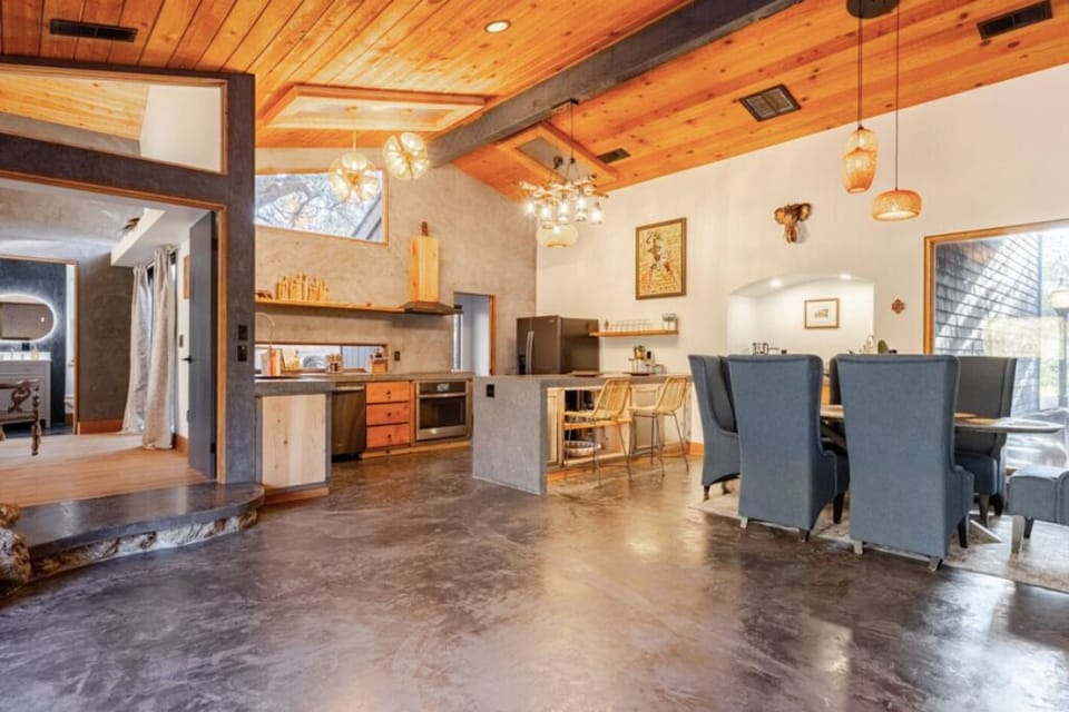 Open space with modern design, wood ceilings, large windows, and cozy lighting.