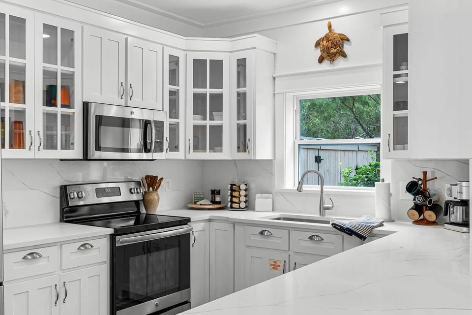 The kitchen is bright and spacious, featuring sleek quartz countertops, stainless steel appliances, and a dedicated coffee station.