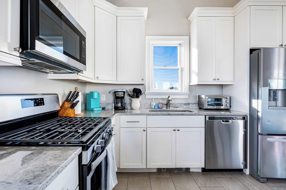 Fully equipped kitchen with basic cooking needs, utensils and plates. 