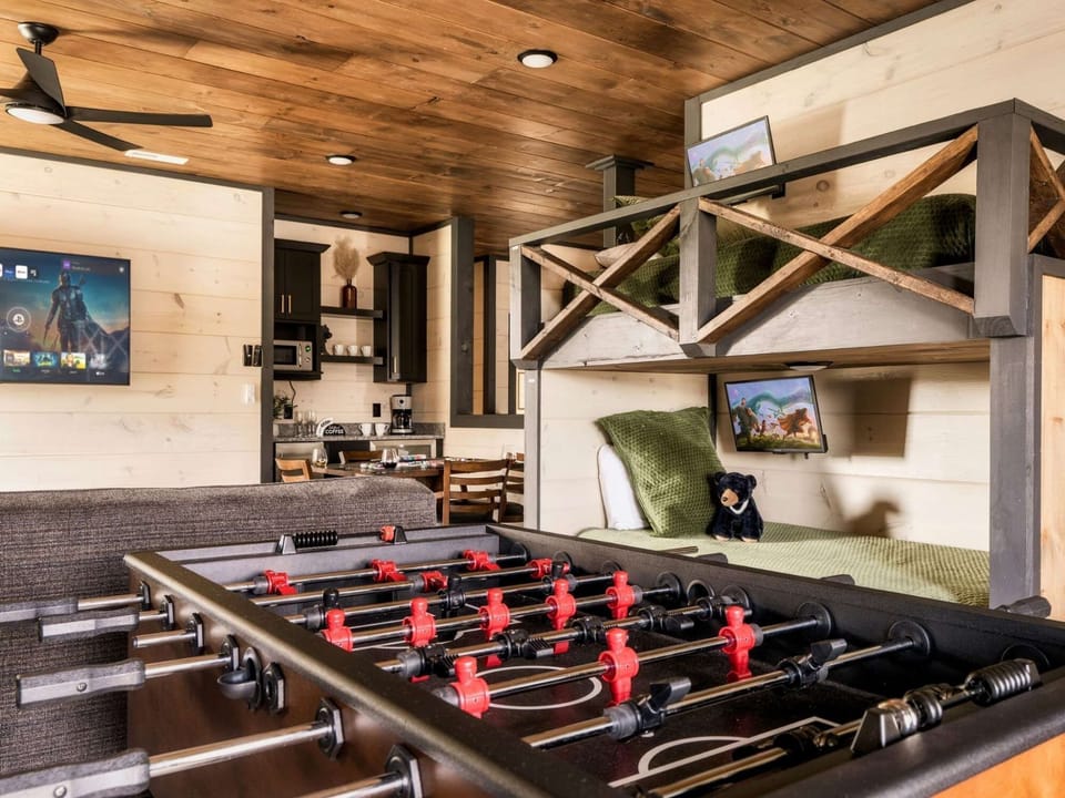 A stylish and functional bunk bed setup with rustic wood finishes, natural light, and games room