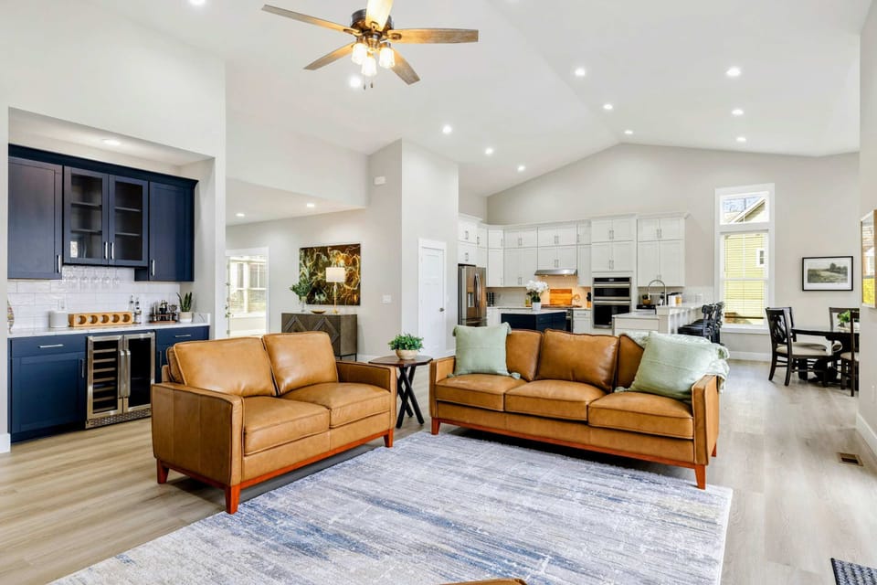 Open-concept living area featuring a cozy seating space, modern kitchen, and stylish wet bar, perfect for entertaining and relaxing.