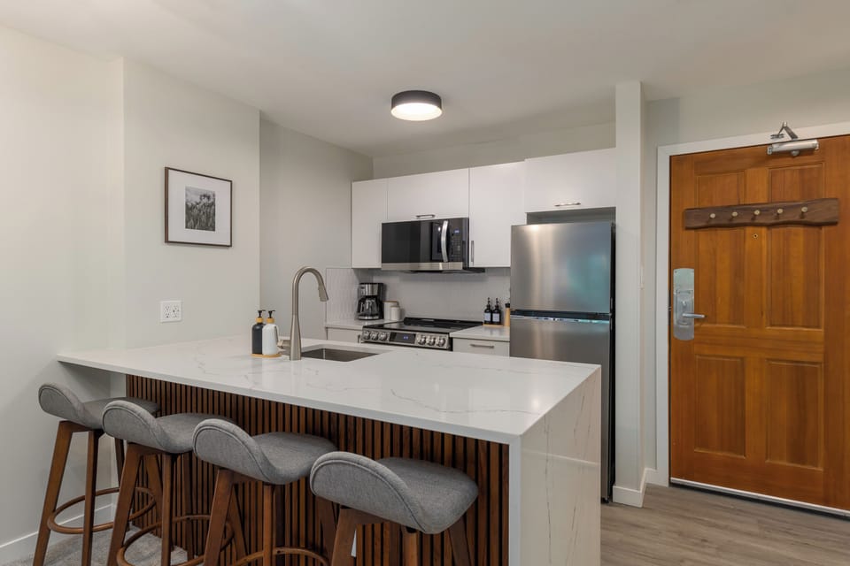 Kitchen/dining room - Four bar stools perfect for casual dining, open kitchen fully equipped for home cooking, patio for two to enjoy a morning coffee or after-ski beer.