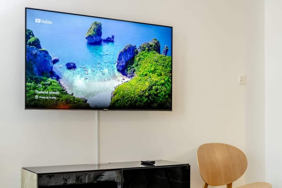 A wall-mounted TV positioned directly in front of the bed for comfortable viewing.