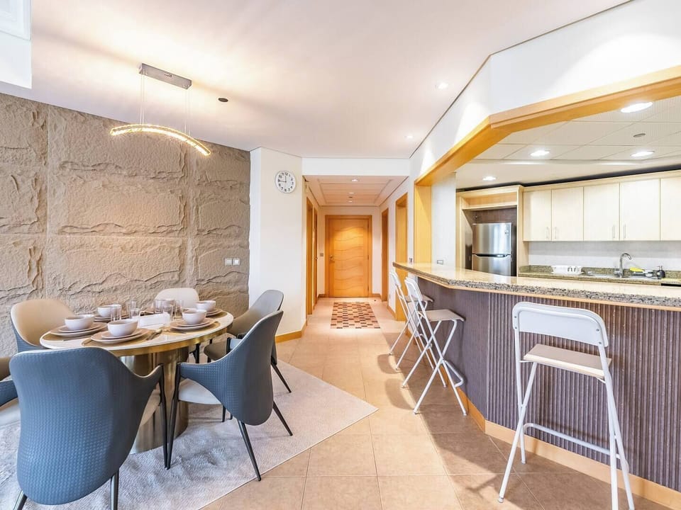 A spacious dining area with seating for six, perfect for family meals and gatherings, plus an additional bar-style dining space with three chairs for casual dining.