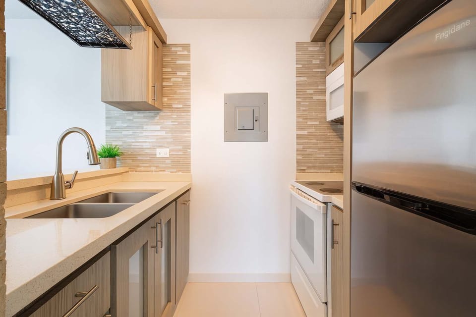 Modern kitchen with sleek countertops, stainless steel appliances, and stylish backsplash—fully equipped and ready for your stay. Perfect blend of functionality and elegance.