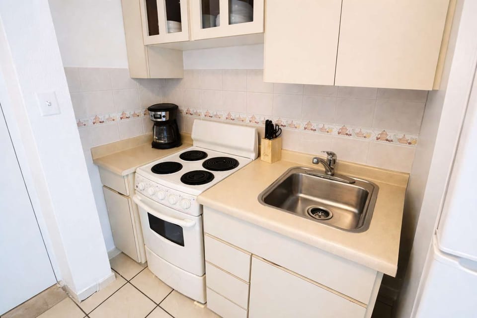 Clean and functional kitchenette with stove, coffee maker, and all the essentials — perfect for preparing breakfast or light meals during your stay.
