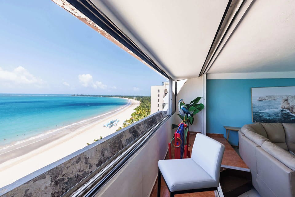 Breathtaking oceanfront balcony with panoramic beach views. Enjoy the sea breeze and turquoise waters from this cozy seating area — the perfect spot for morning coffee or sunset relaxation.