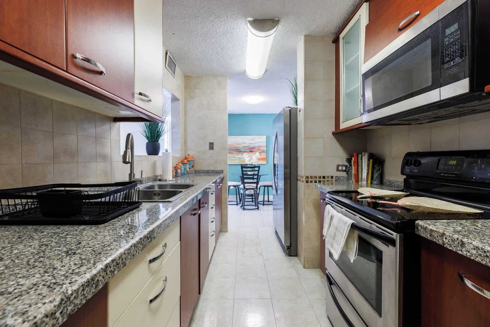 Modern galley kitchen with granite countertops, stainless steel appliances, and elegant cabinetry — designed for convenience and style during your island getaway.