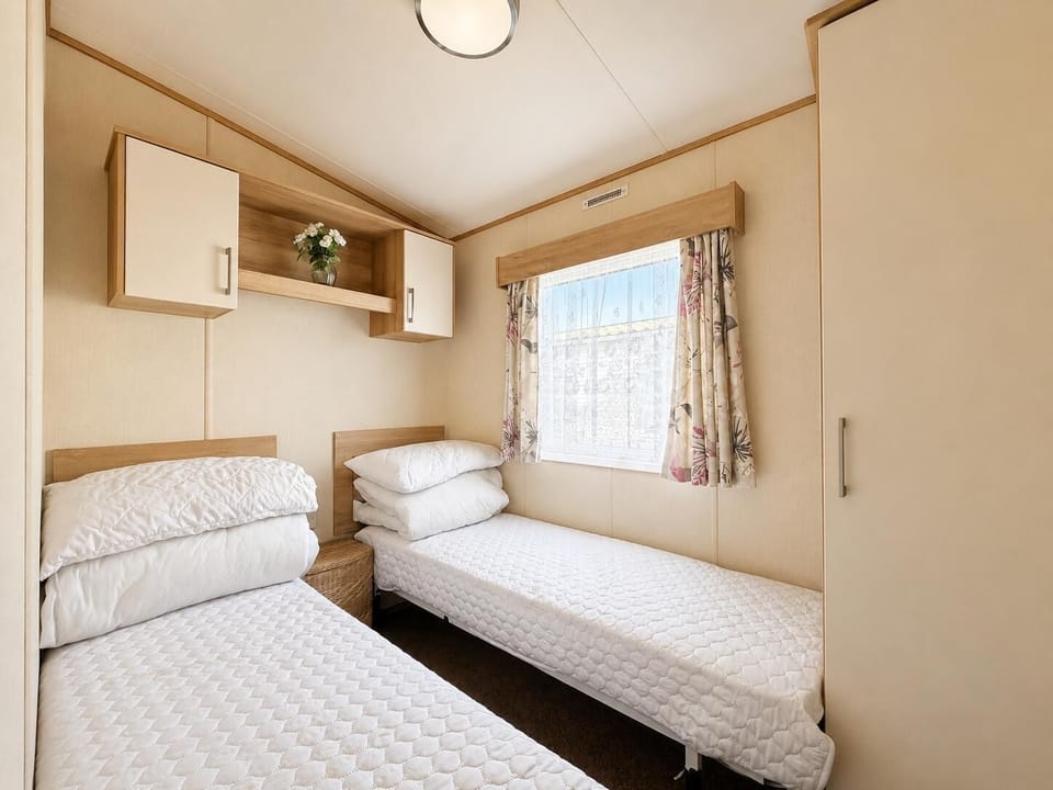 The caravan bedroom is a snug retreat, ideal for unwinding after a day of adventure.