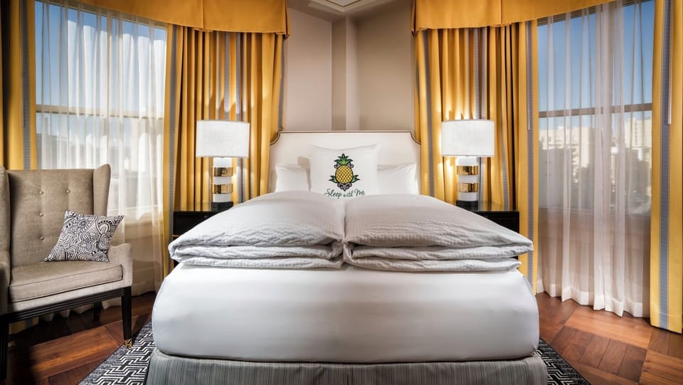 Unwind in a sunlit king bed with crisp linens.