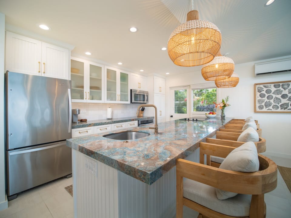 Gourmet kitchen with island seating, fully equipped for preparing meals and entertaining in your Maui retreat.