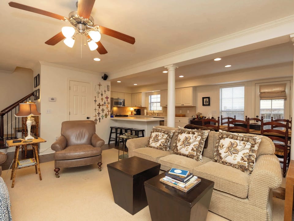 A central view of the lounge space highlighting the plush sofa and the seamless transition into the kitchen and dining zones.