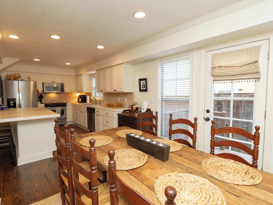 A dedicated dining space with a large wooden table and high-back chairs, situated right next to the kitchen for easy serving.
