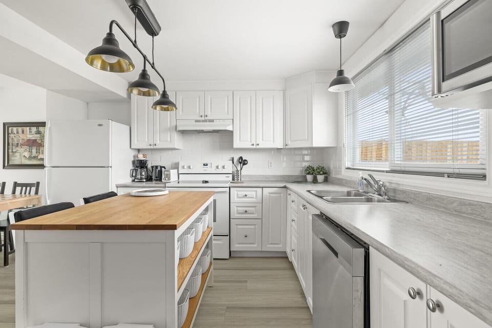 Modern fully equipped kitchen with central island, updated appliances, and plenty of natural light.