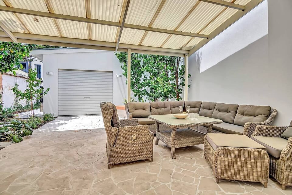 The back patio caters to alfresco dining with comfortable wicker furniture and a BBQ for summer gatherings.
