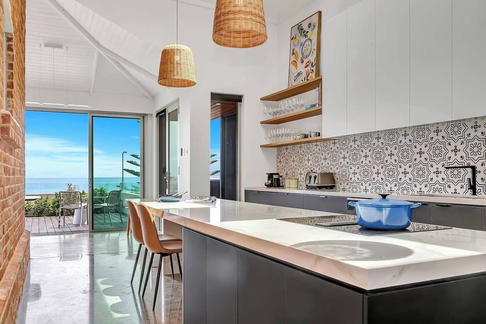 Cook with ease in the modern kitchen, showcasing sleek cabinetry, high-end appliances, and a stunning patterned backsplash.
