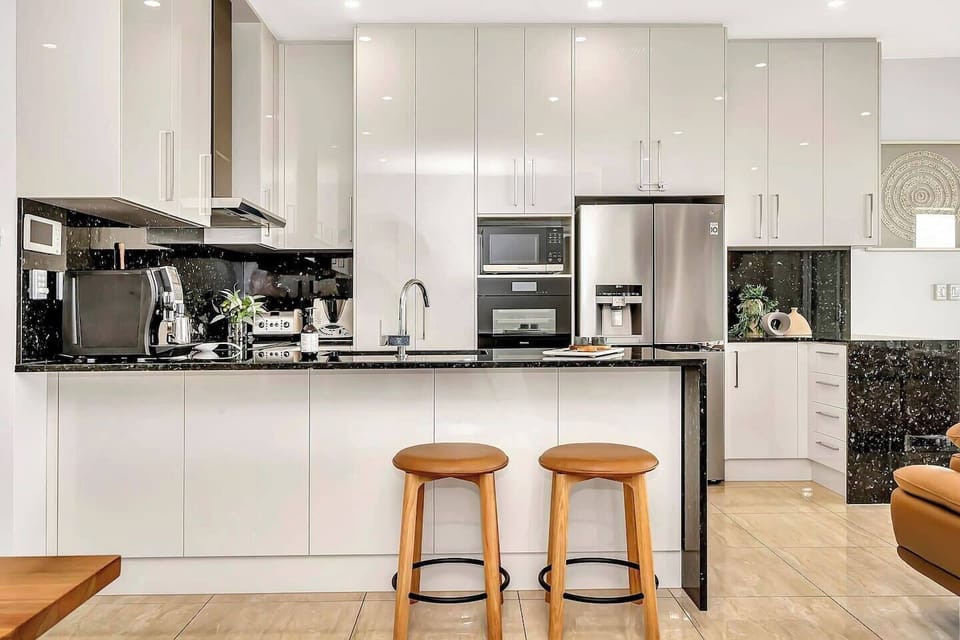 Prepare meals in the gourmet kitchen equipped with premium appliances, ample counter space, and a sleek island bench.