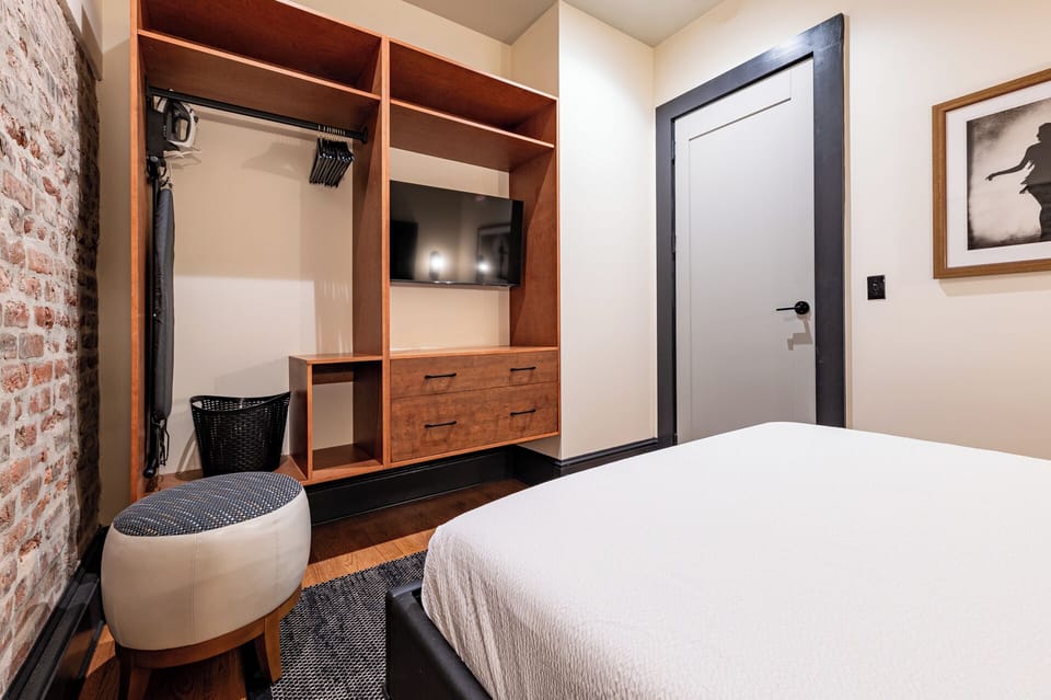 Bedroom 1 - Closet space equipped with hangers, laundry hamper, and iron with ironing board.